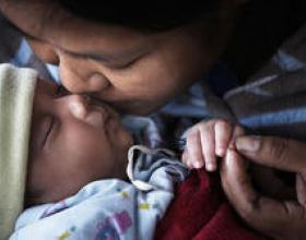 A mother kisses her infant in Chiangmai Province, Thailand. © 2010 Hansa Tangmanpoowadol, Courtesy of Photoshare